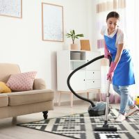 Woman,Hoovering,Carpet,In,Living,Room.,Cleaning,Service