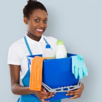 Portrait,Of,A,Smiling,African,Female,Janitor,Holding,Cleaning,Equipment